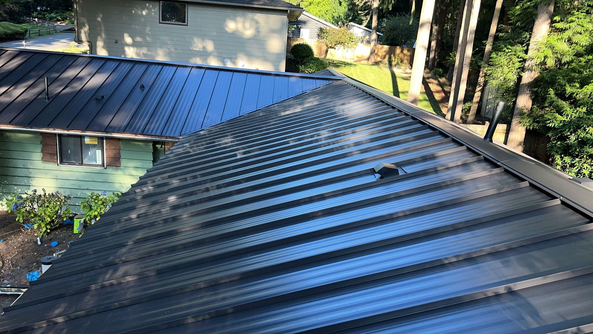 A black metal roof is sitting on top of a house.