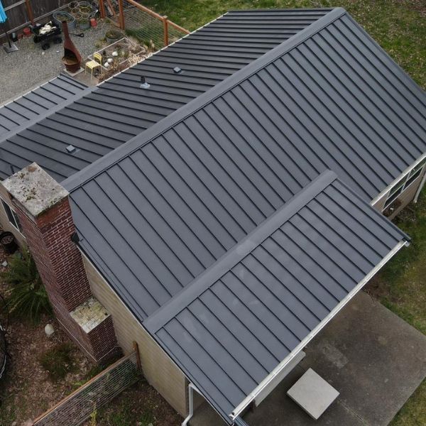 An aerial view of a house with a black metal roof.