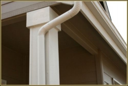 A white gutter on the side of a house