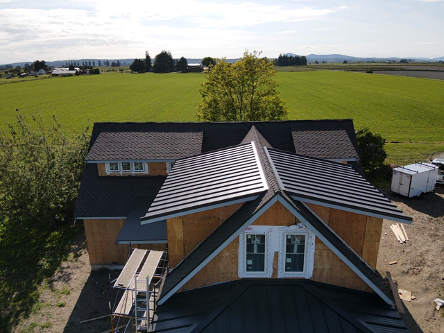 An aerial view of a house with a black roof