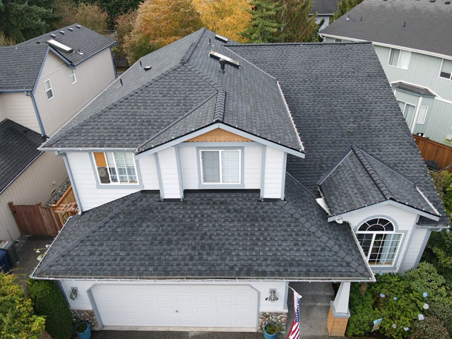 An aerial view of a two-story house with a gray shingle roof.