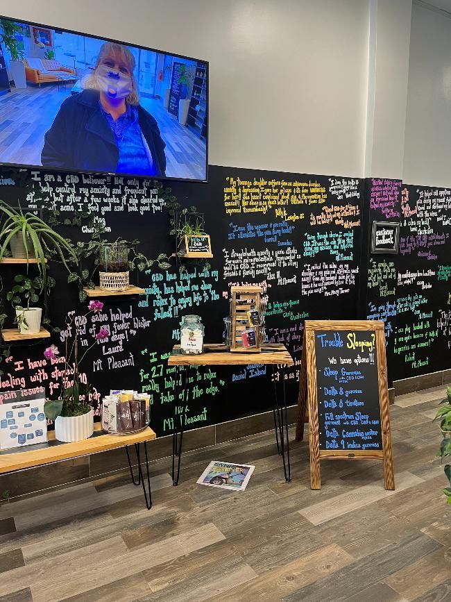 A room with a chalkboard and a large tv on the wall.