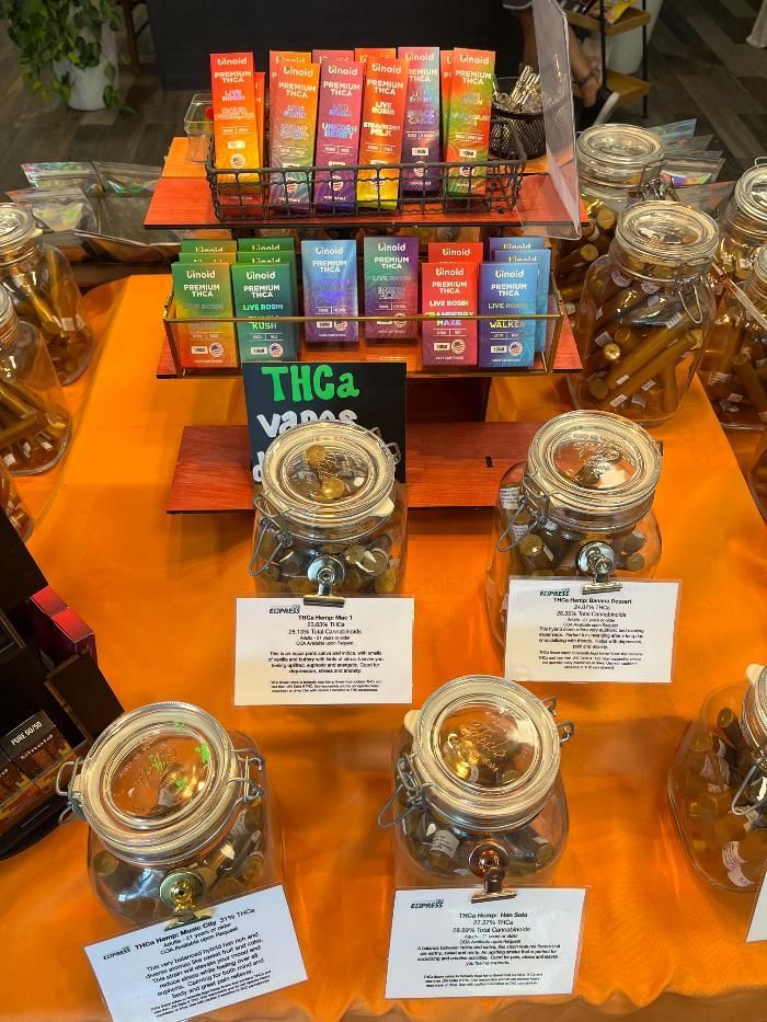 A table with jars of candy and a sign that says thca on it.