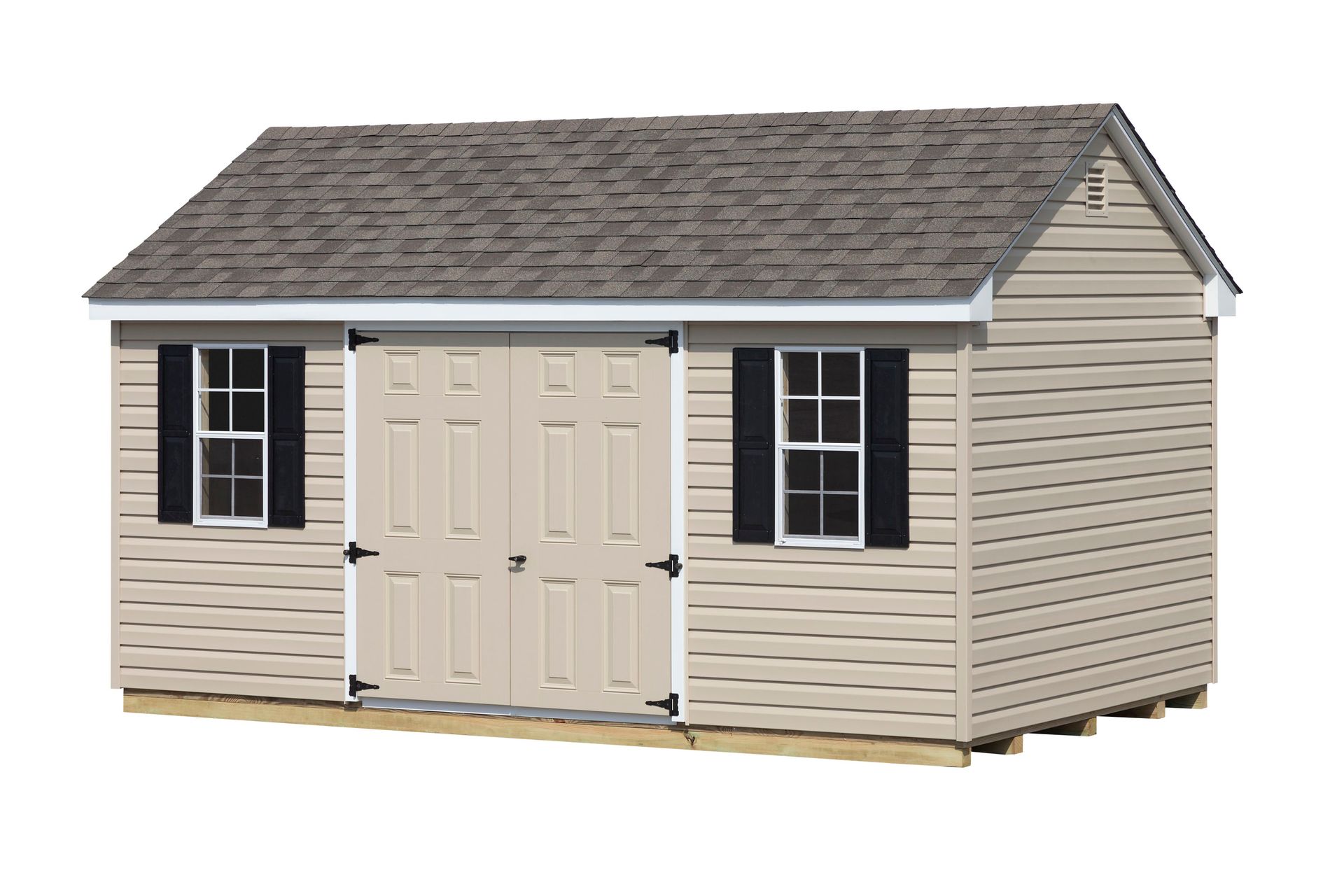 Tan shed with a gable roof, two windows with black shutters, and double doors.