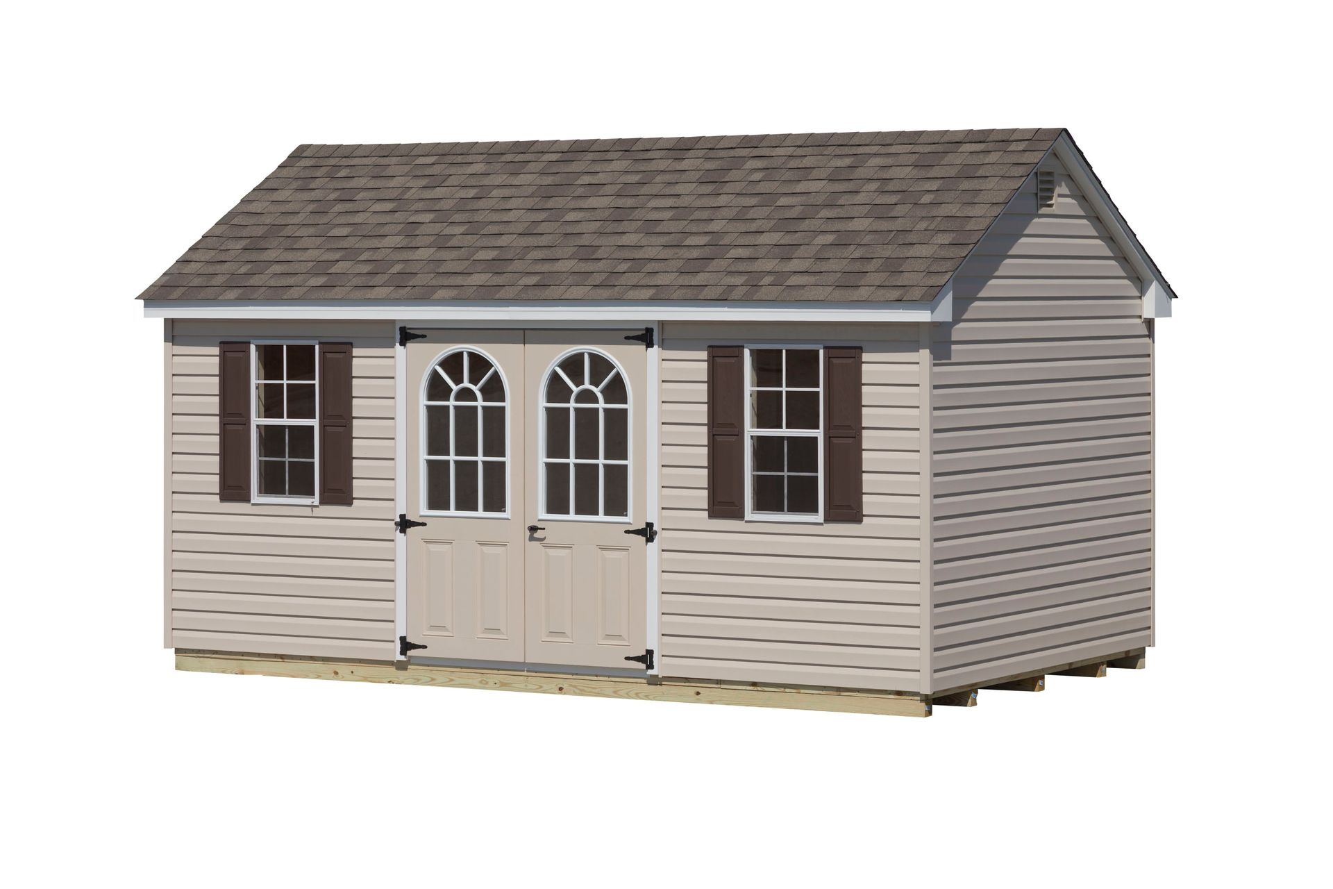 Tan shed with brown roof and shutters, double arched doors, and two windows.