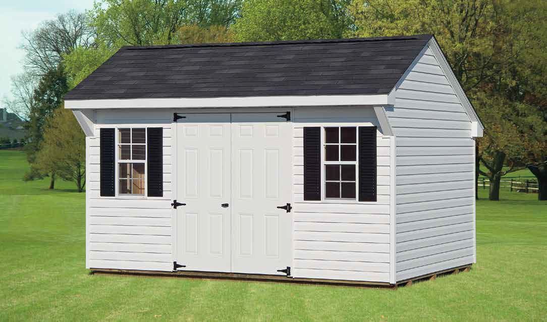 White shed with black roof, shutters, and double doors on green grass.