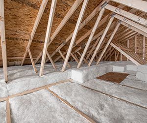 Attic interior with exposed wooden rafters and insulated floor panels