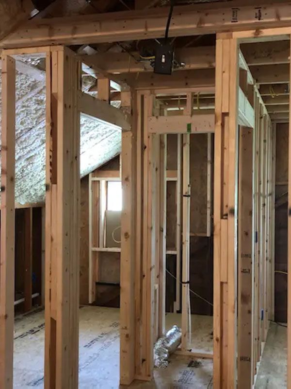 Interior of a house under construction with exposed wooden framing and unfinished walls.