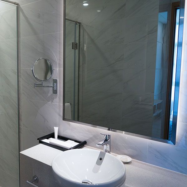 Modern bathroom vanity with round sink, mirror, and wall-mounted towel ring