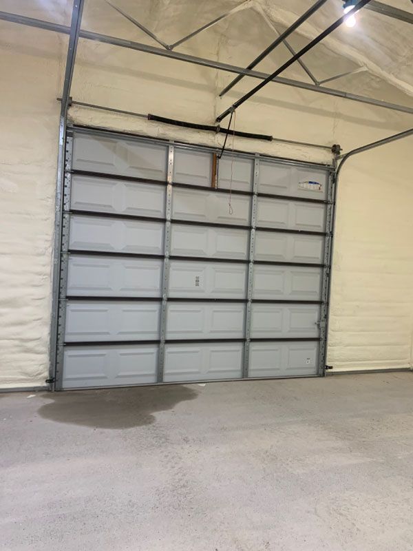 Closed gray industrial garage door inside a light-colored warehouse.