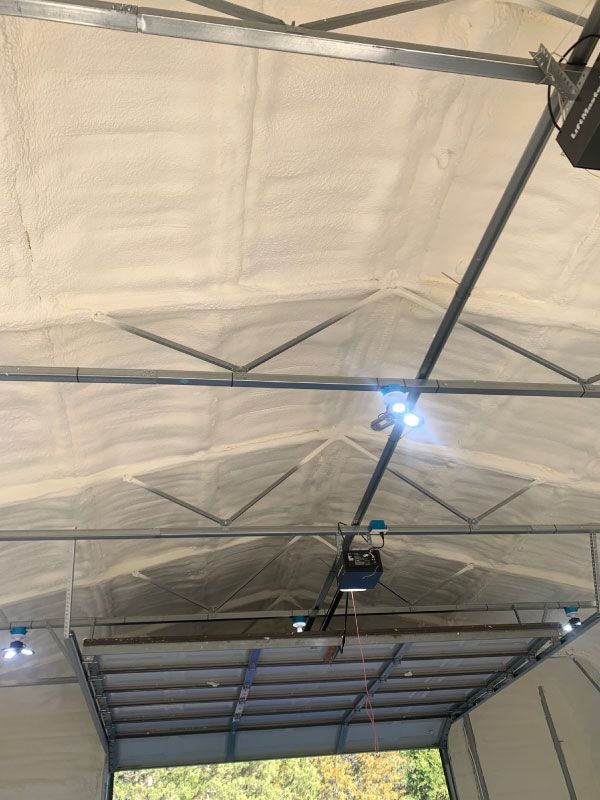 Interior of a tented structure with white fabric ceiling, metal trusses, and blue overhead lights