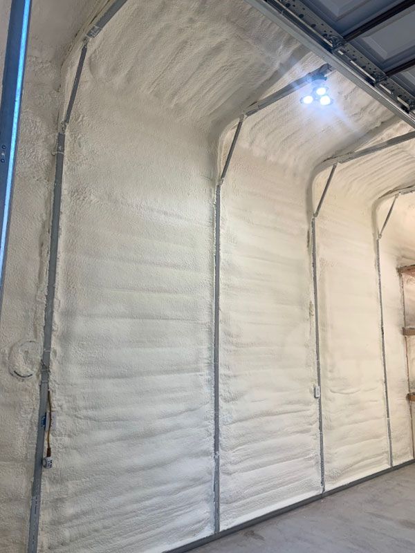 White insulated warehouse doors lining a concrete hallway with overhead lights