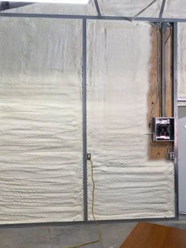 Large white insulated wall panels with a vertical seam and a small electrical box on the right side.
