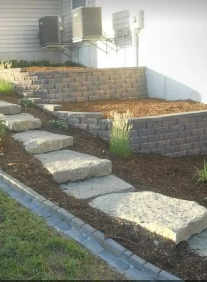 Stone steps leading up a hillside with a retaining wall and mulch.