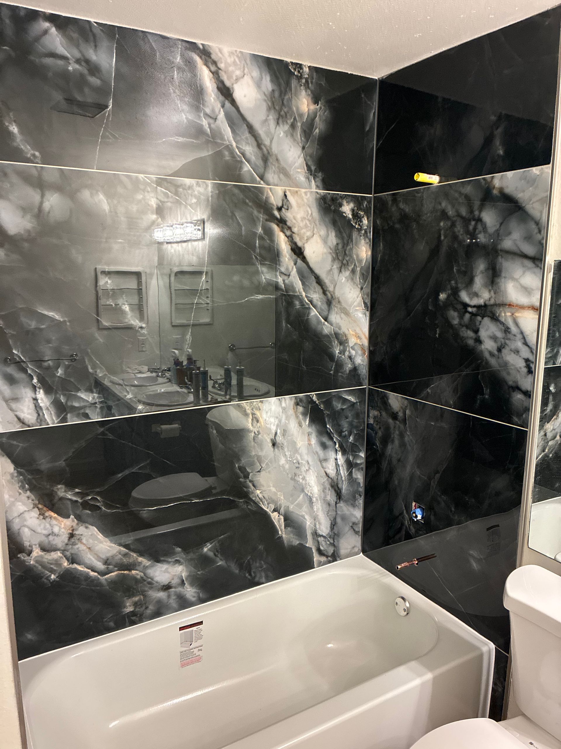 Remodeled bathroom with marble countertop and new mirror