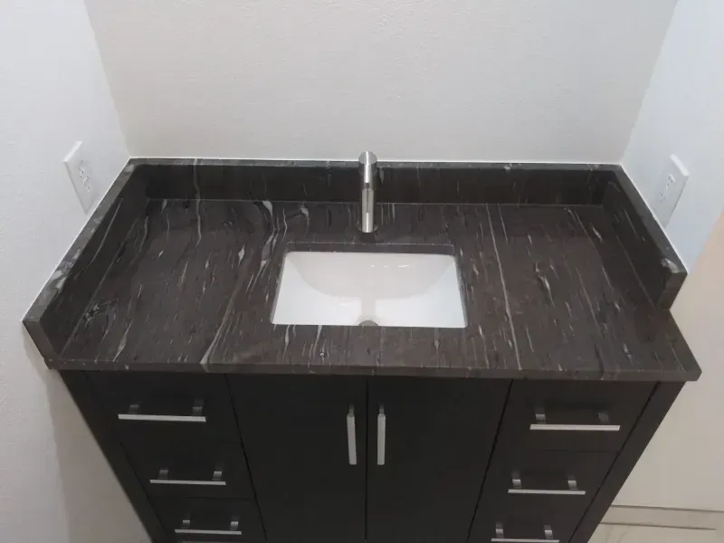 A bathroom vanity with a sink and a faucet
