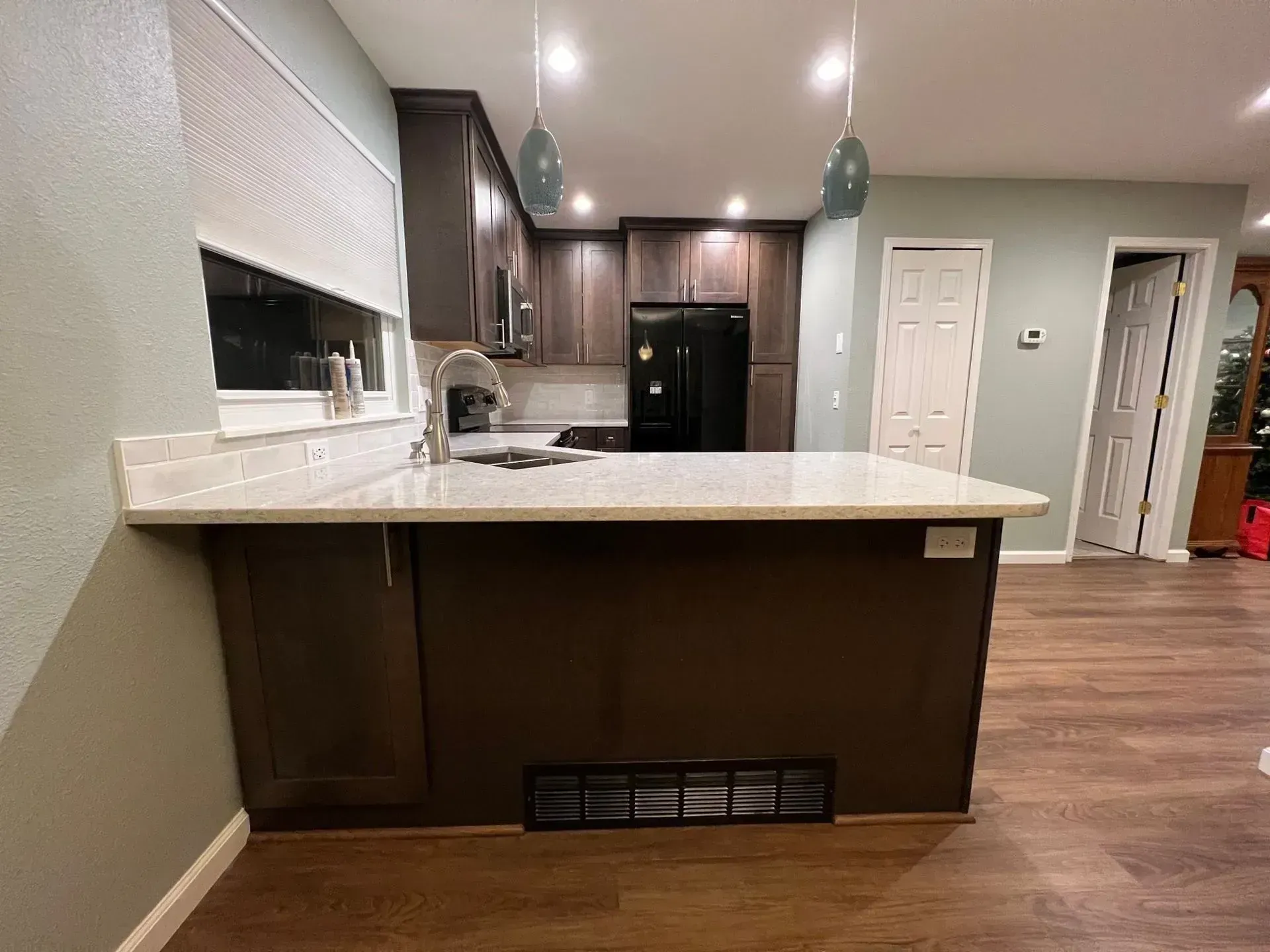 A kitchen with a large island and a refrigerator.