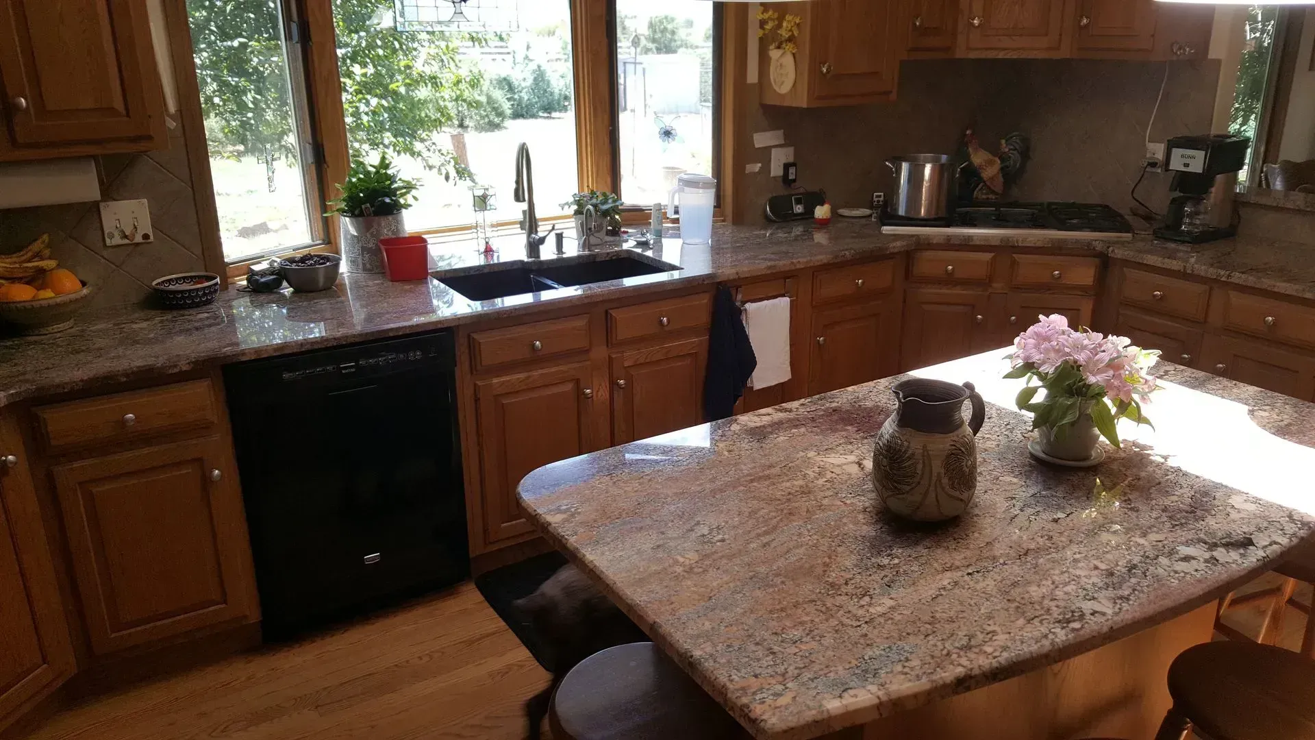 A kitchen with granite counter tops and wooden cabinets