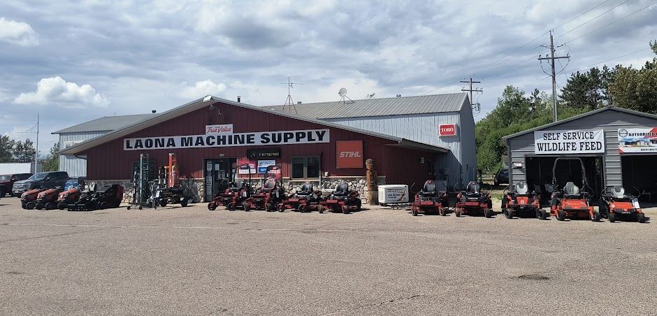 Farm and home supply store with ATVs and tractors parked outside on a cloudy day