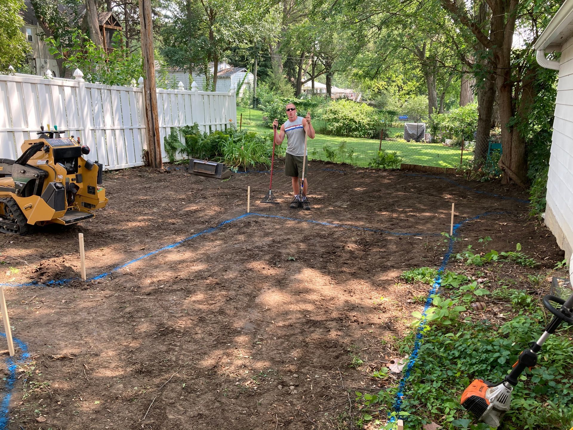 a man is standing in the dirt in front of a house
