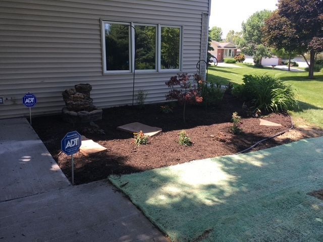 The backyard with green lawn next to the house.