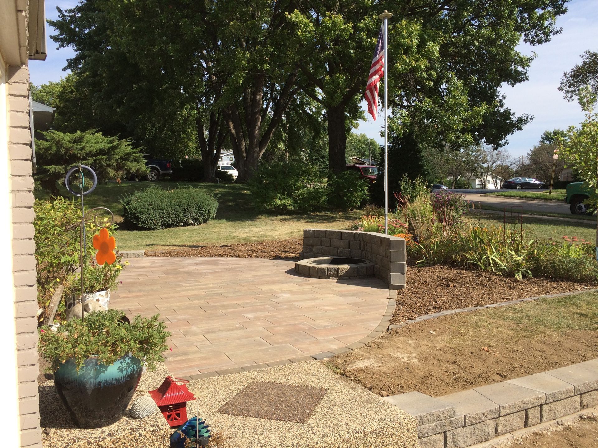 a fire hydrant in front of a house with an american flag in the background