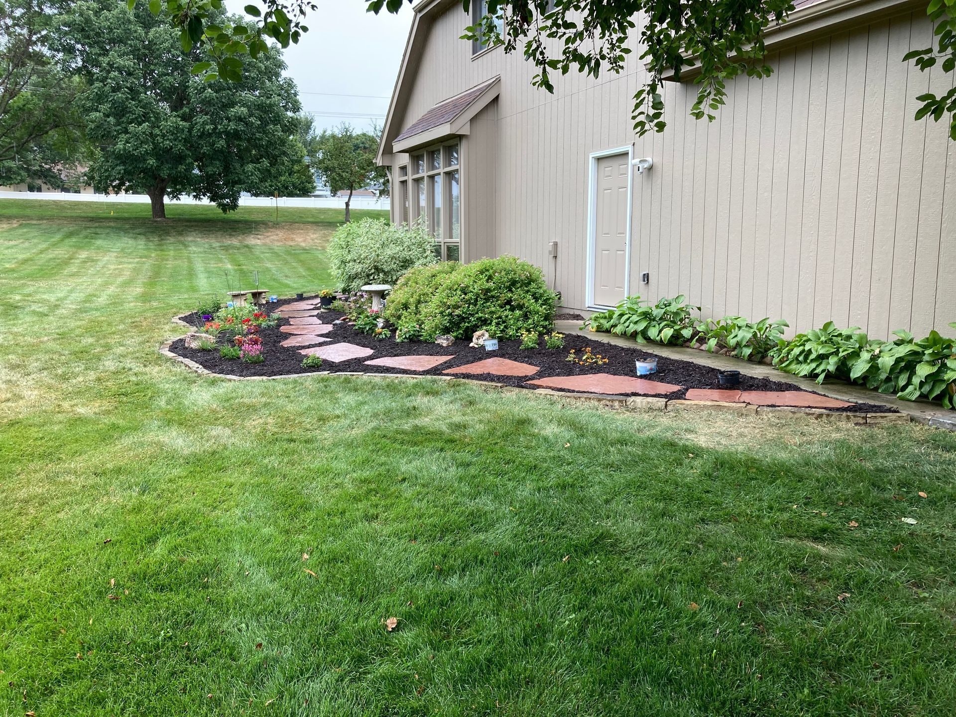 a house with a lush green lawn and a stone walkway in front of it