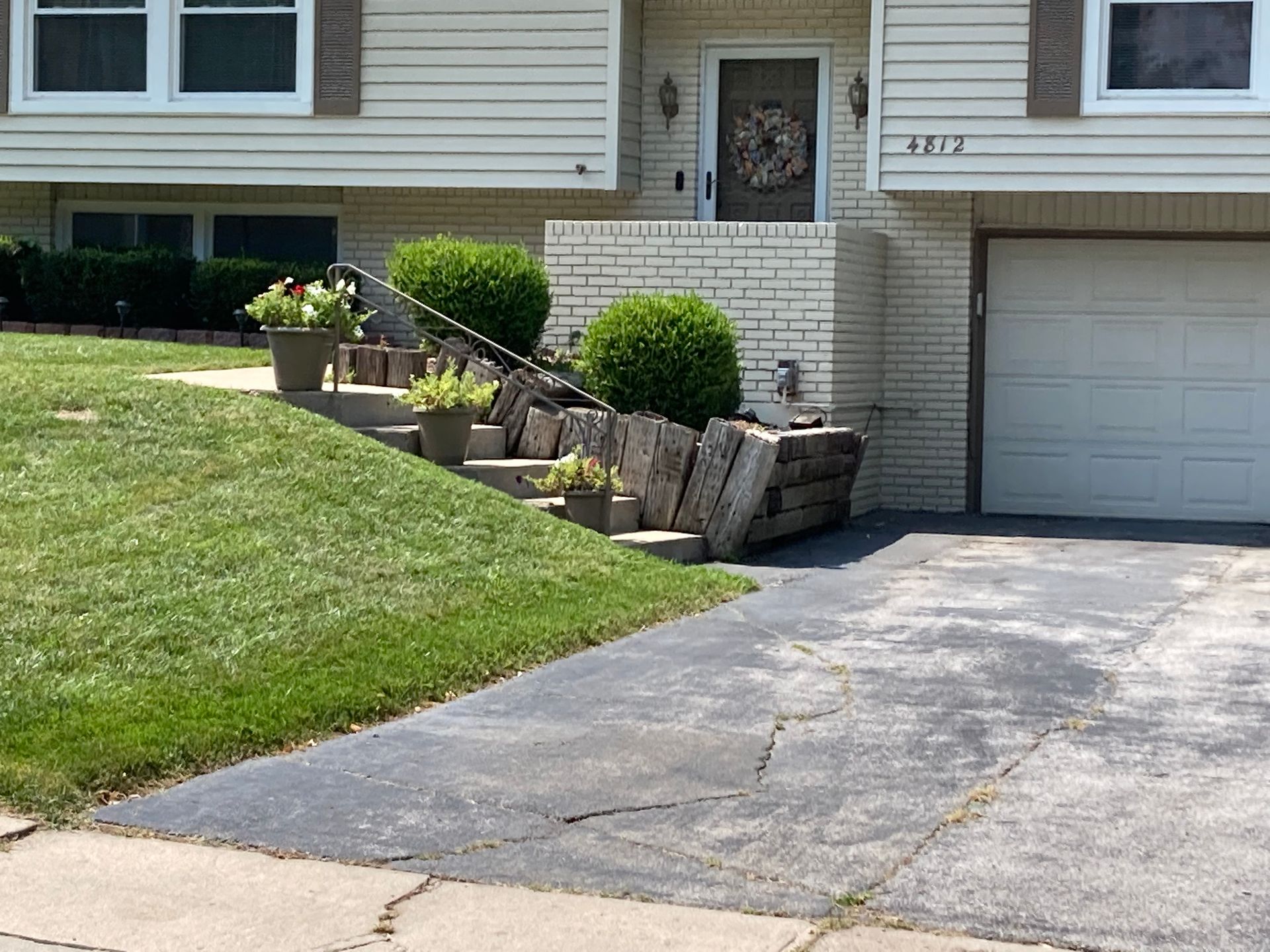 a house with a driveway and stairs leading up to the front door