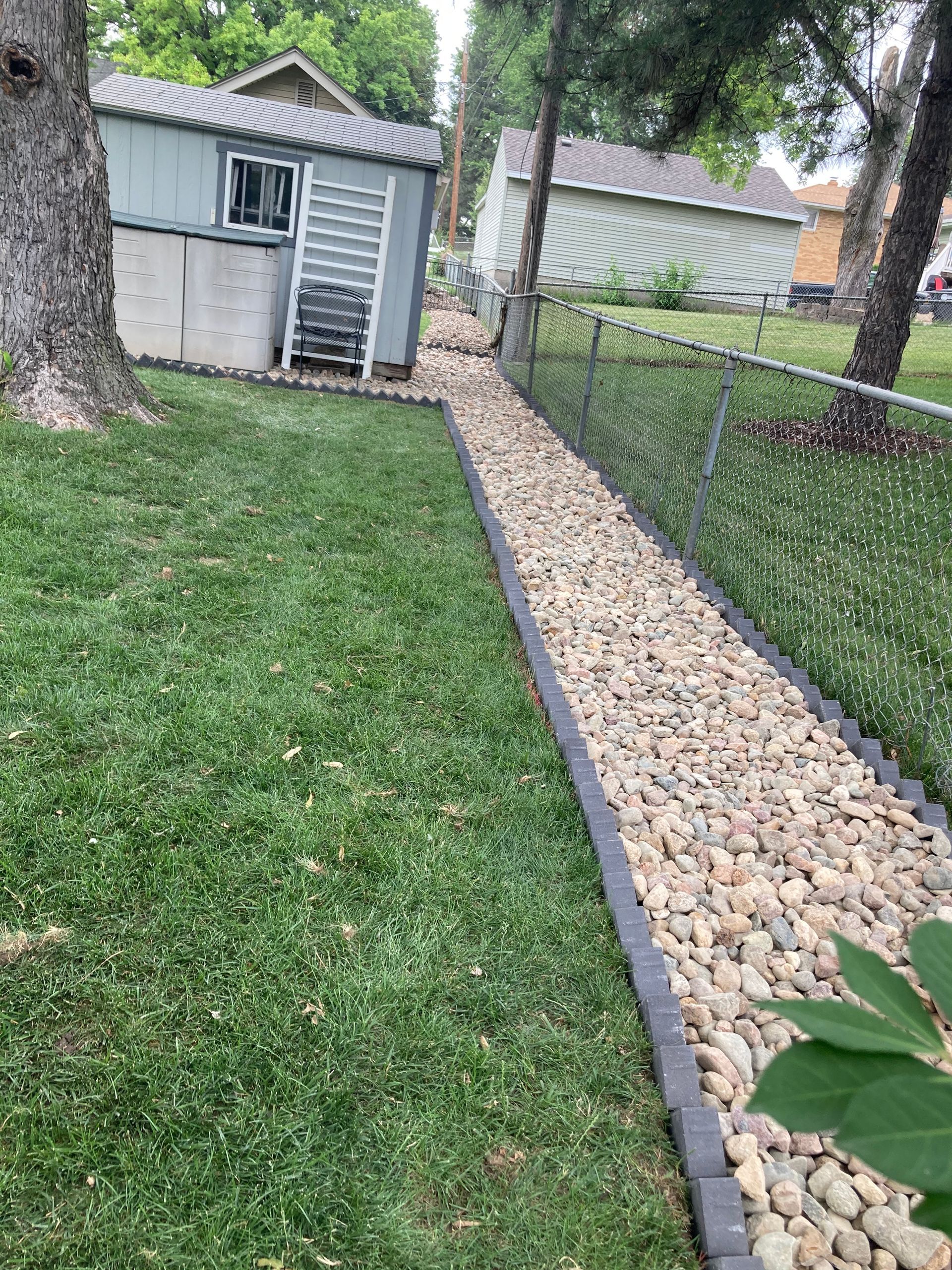 a stone walkway leading to a shed in a yard