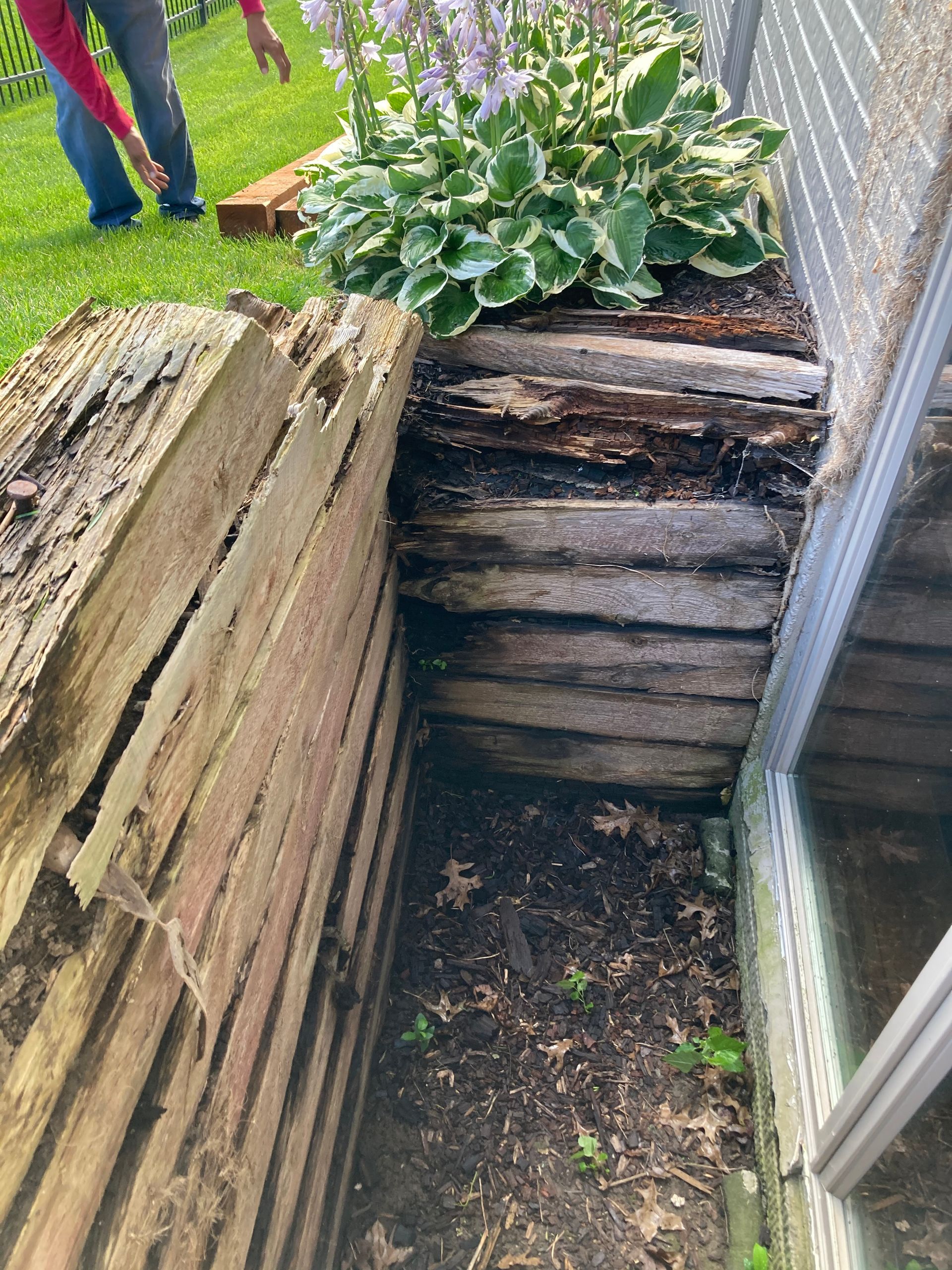 a person is standing next to a pile of wood next to a window