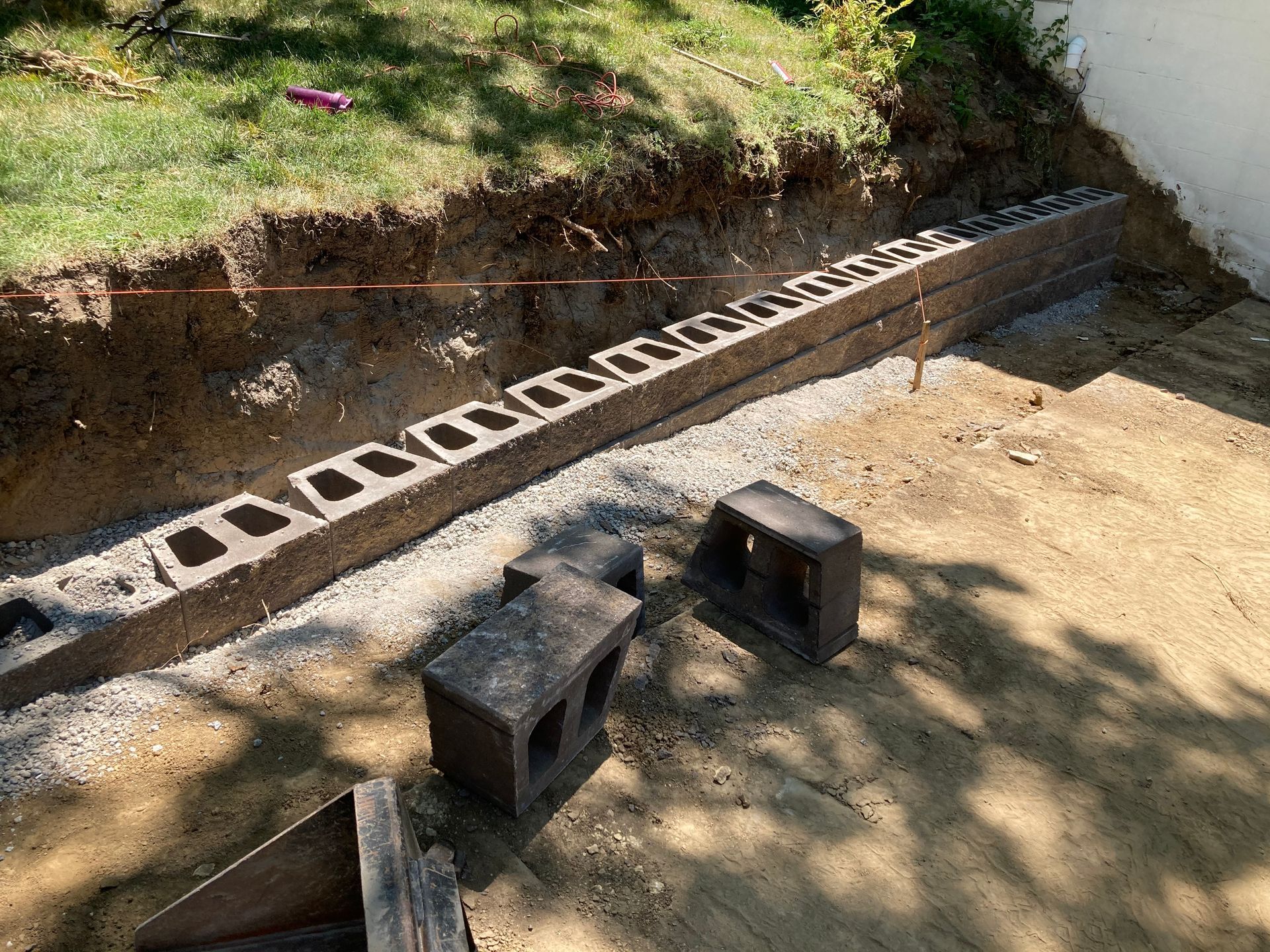 a brick wall is being built in a backyard