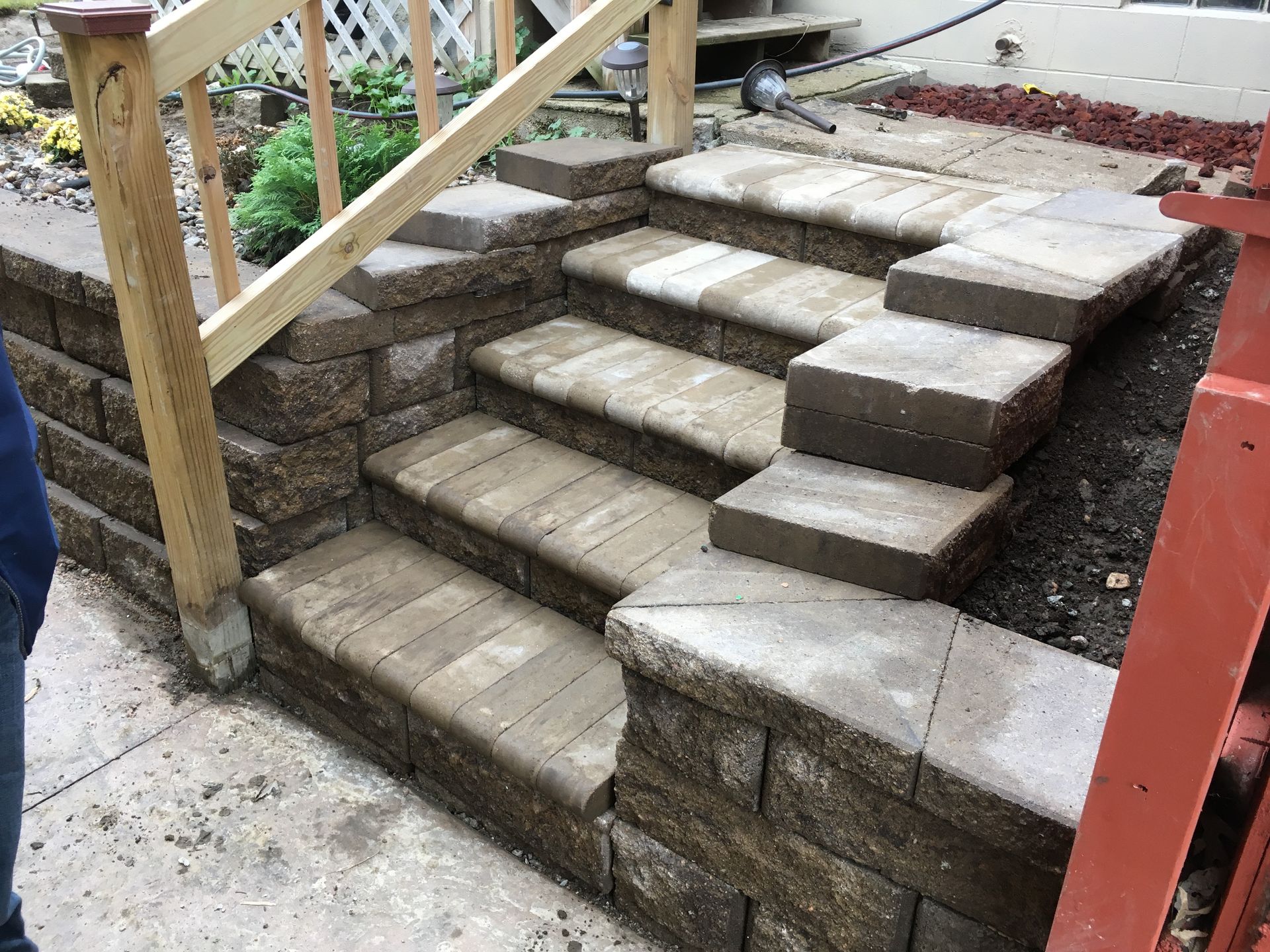 a person is standing next to a set of stairs with a wooden railing