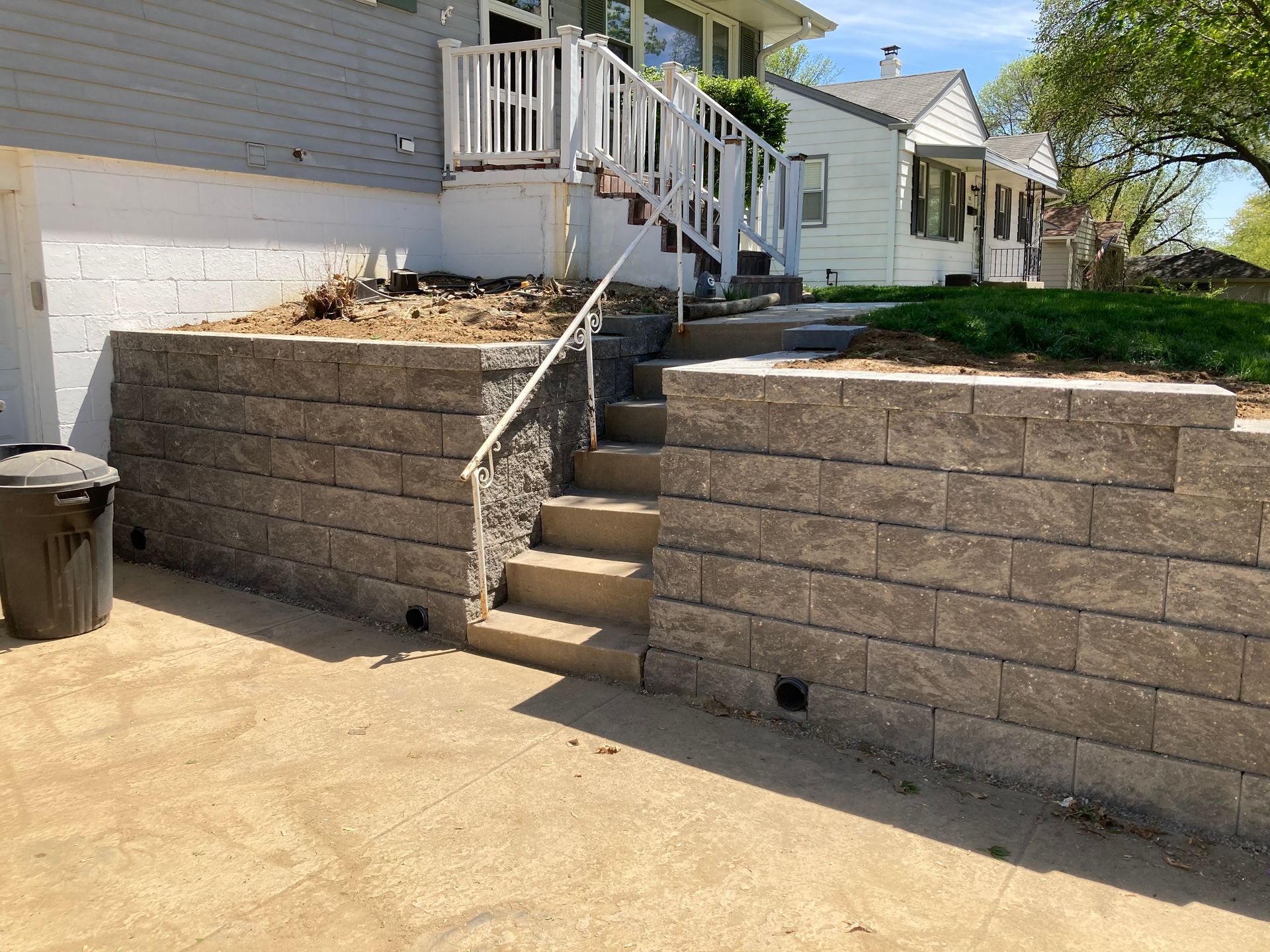 a brick wall with stairs leading up to a house