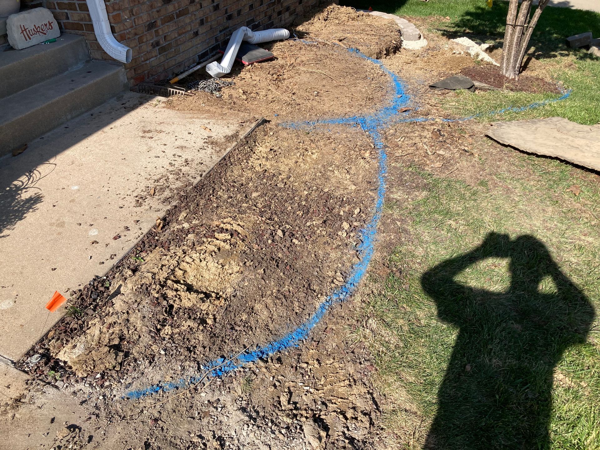 a person is taking a picture of a hole in the ground in front of a house