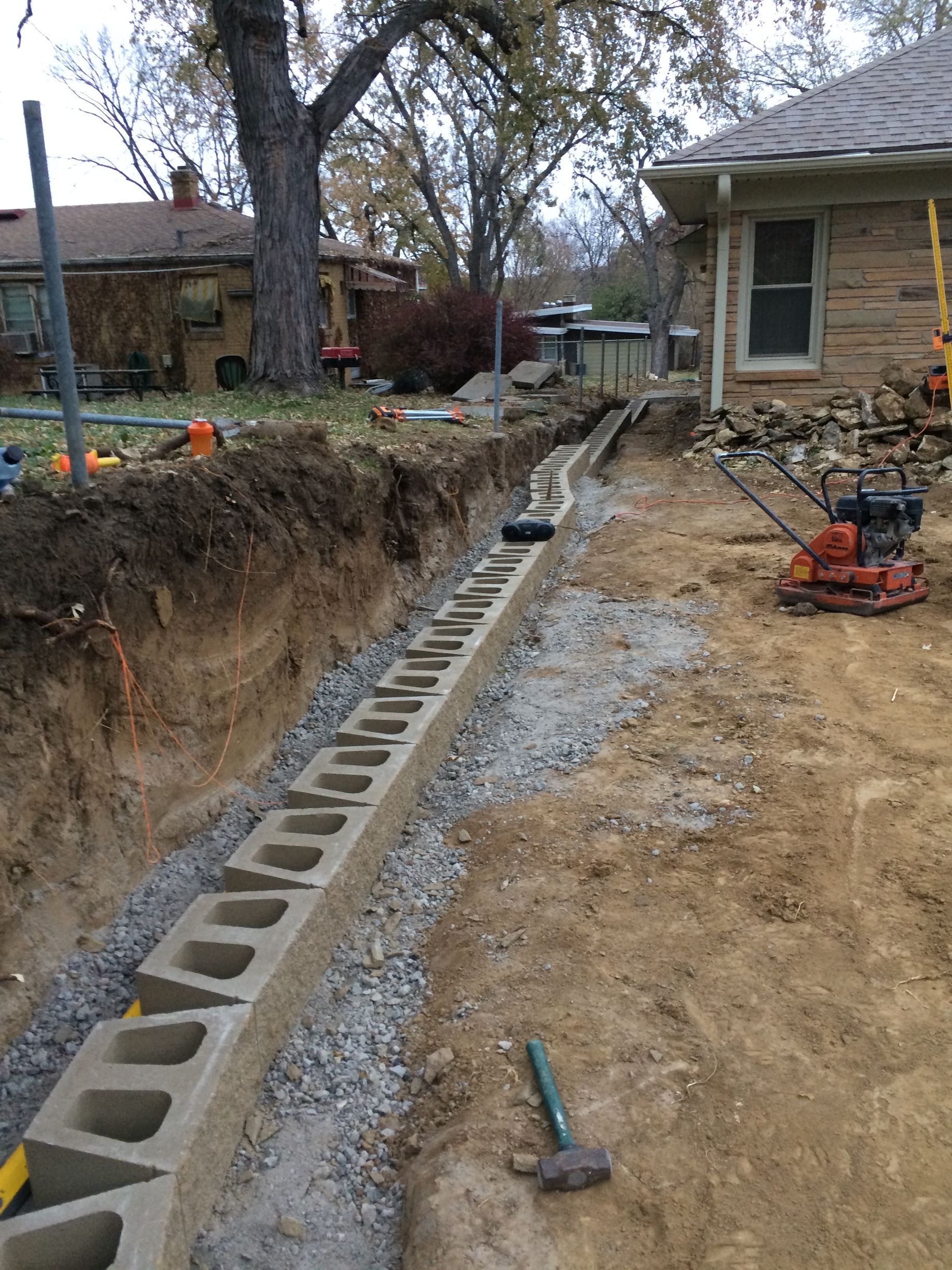 a concrete block wall is being built in front of a house