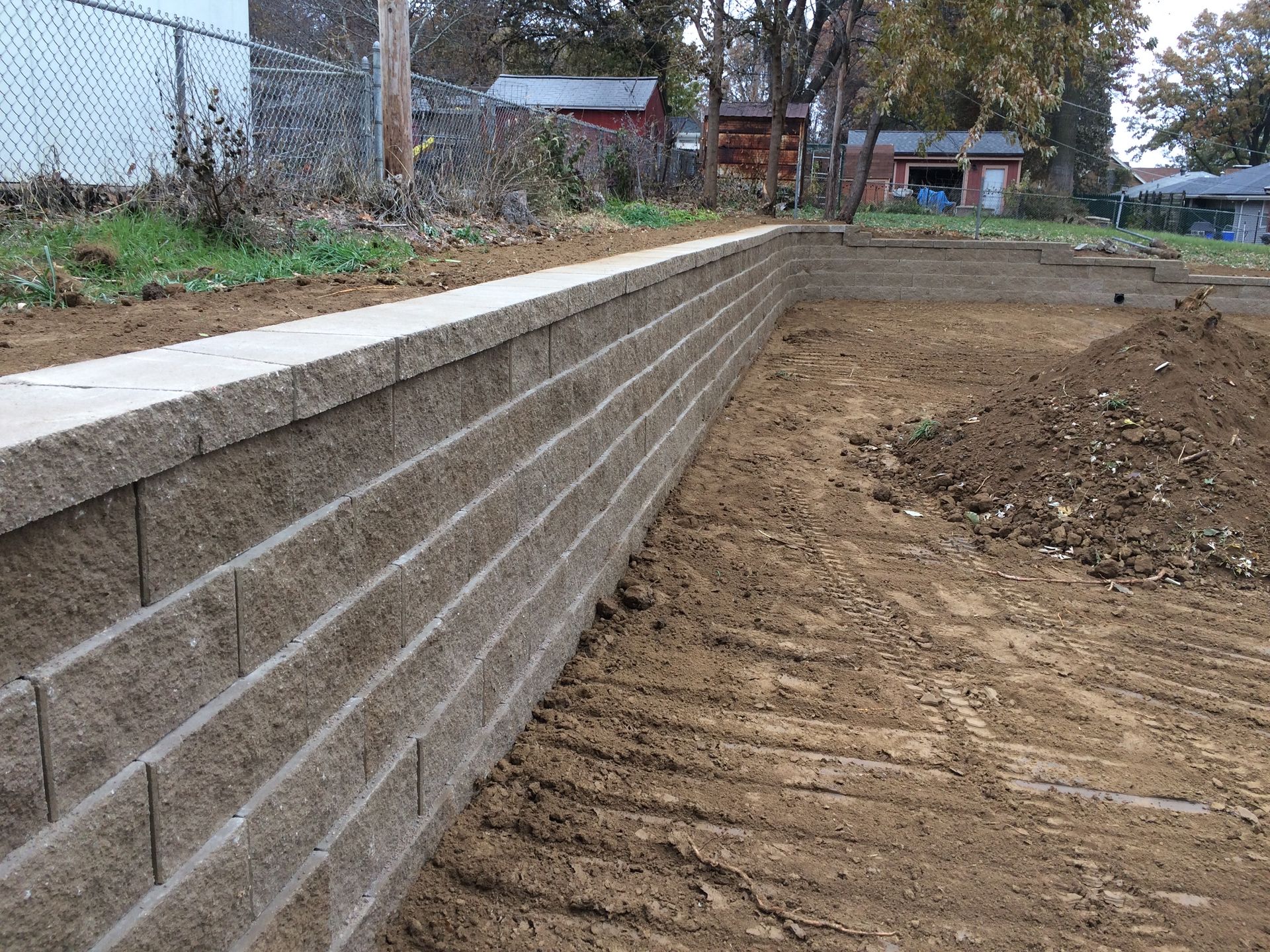 a brick wall is sitting in the middle of a dirt field