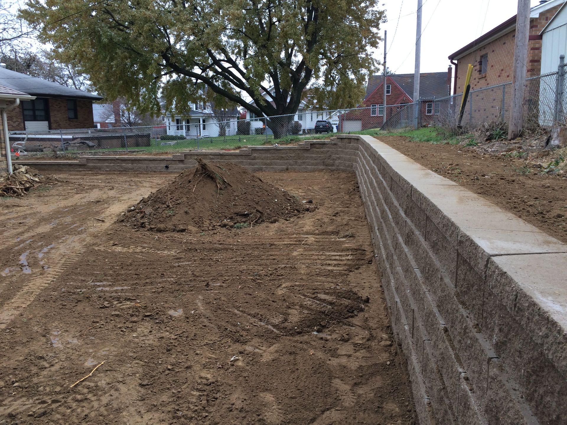 a large pile of dirt is sitting next to a brick wall