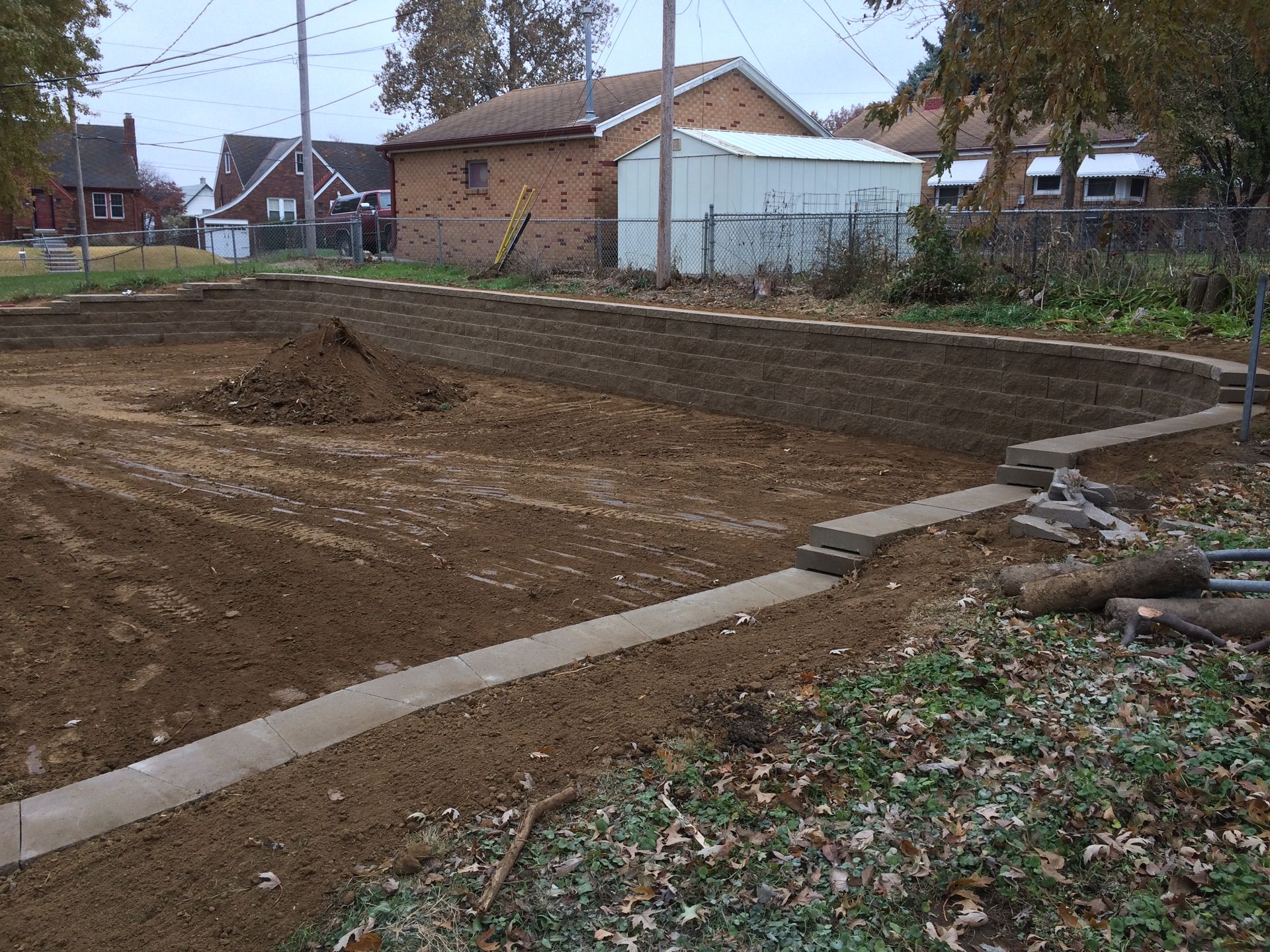 a dirt road with a brick house in the background
