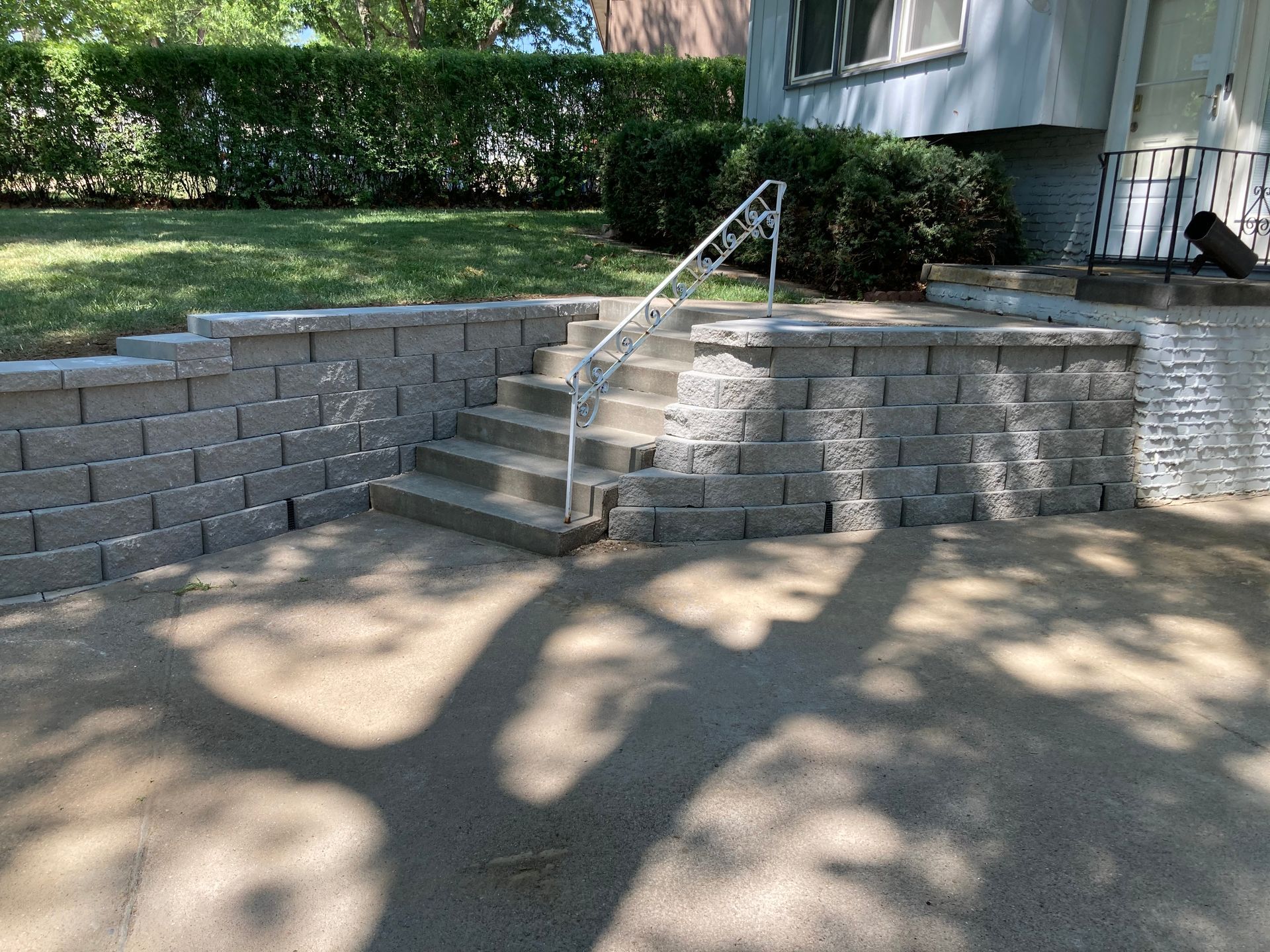 a brick wall with stairs and a railing in front of a house