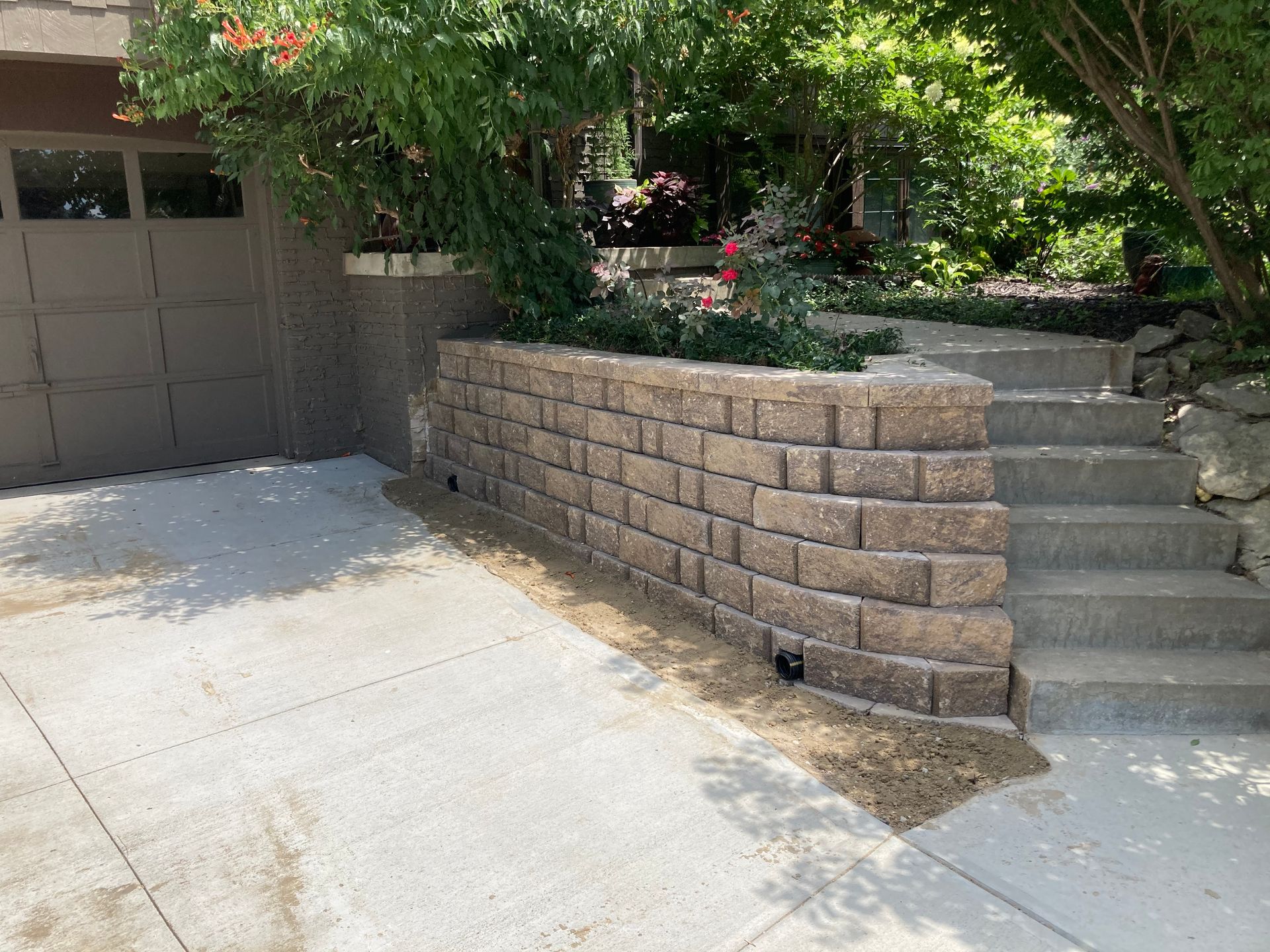 a brick wall with stairs leading up to a garage