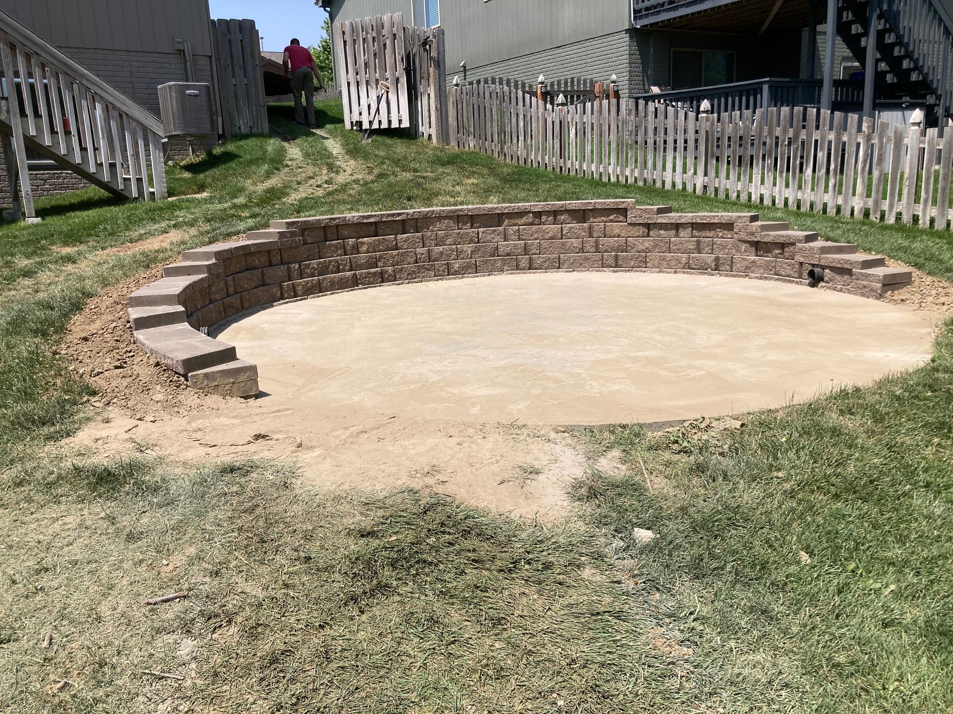 a fire pit is being built in the backyard of a house