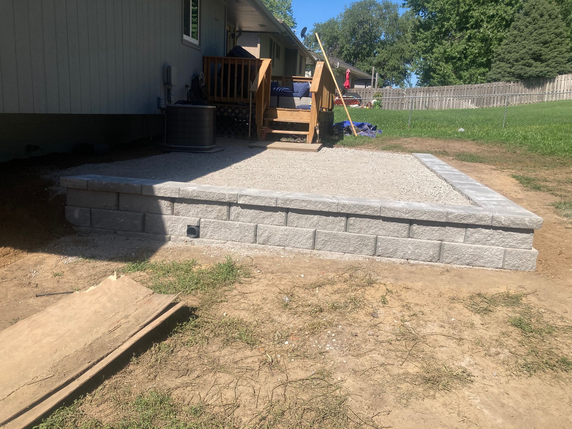 a patio with stairs leading up to it is being built in the backyard of a house