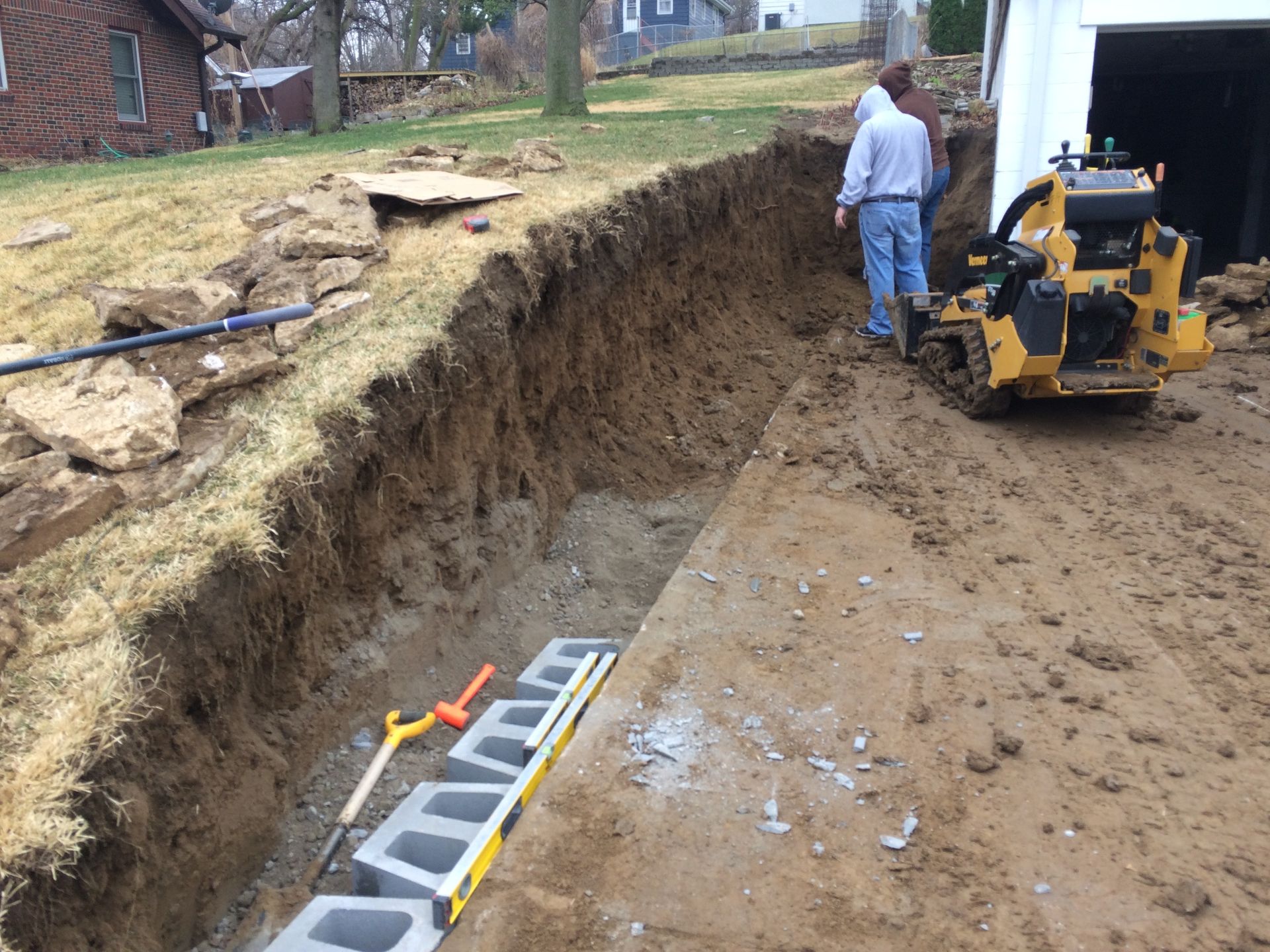 a man is standing in the dirt next to a bulldozer