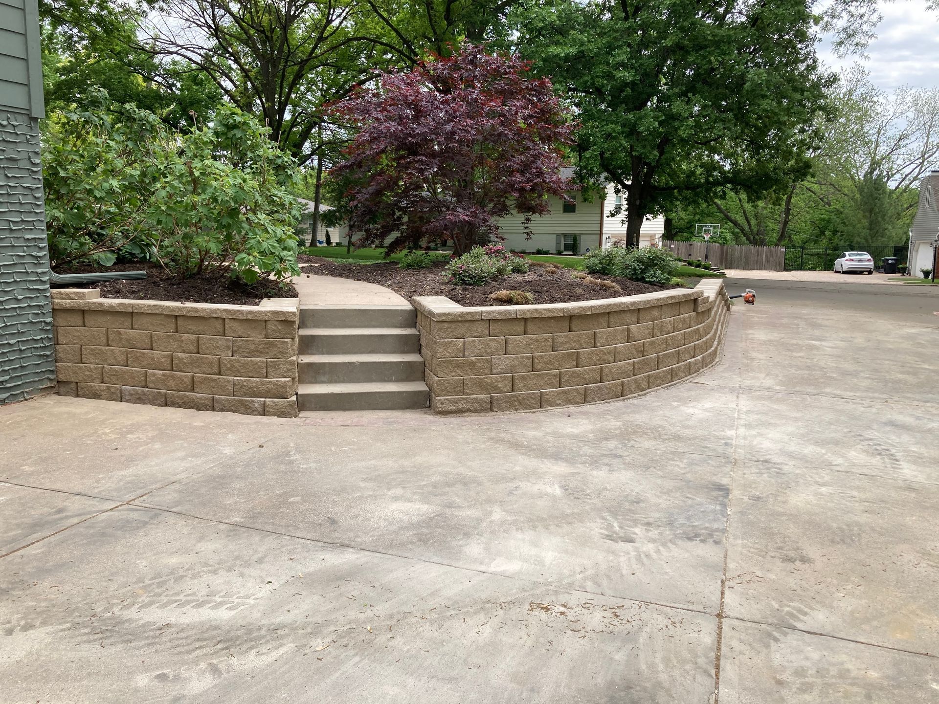 a brick wall with stairs leading up to it in a driveway