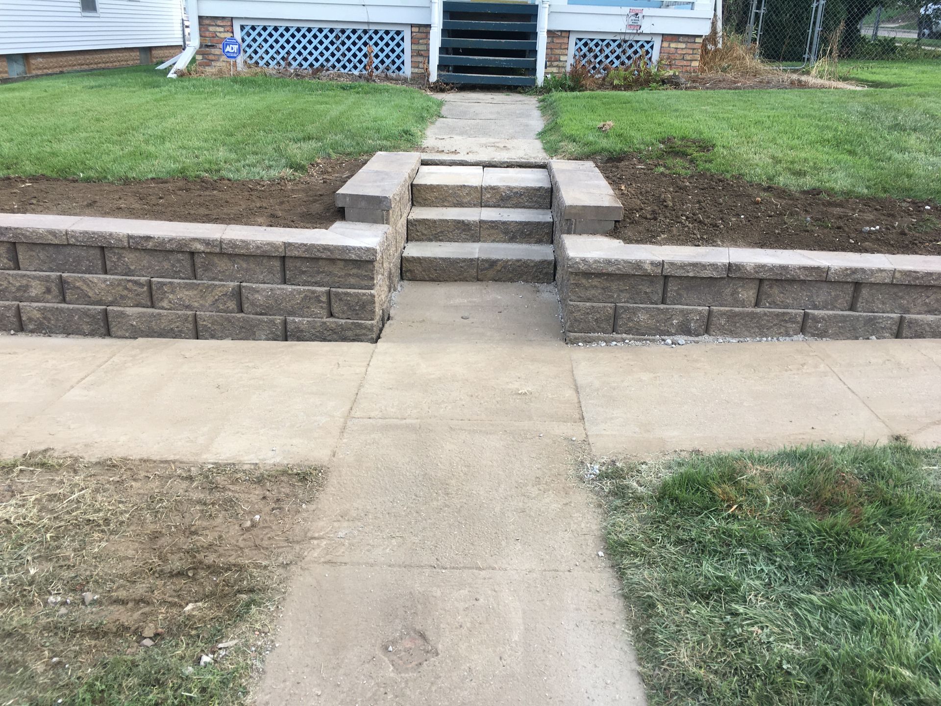 a stone wall with stairs leading up to a house