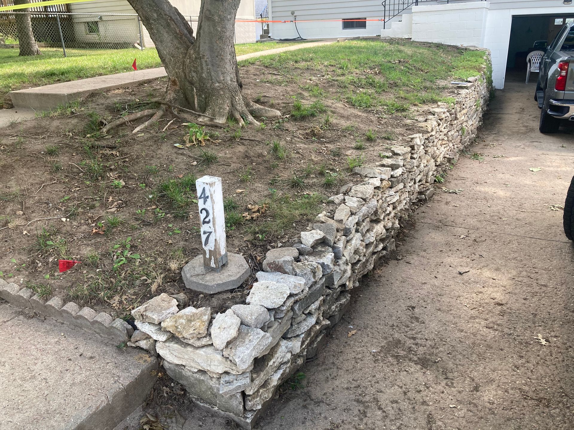 a car is parked in front of a stone wall