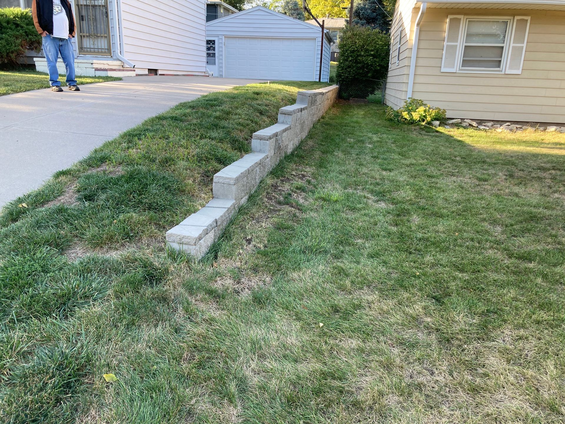 a man is standing in the grass in front of a house