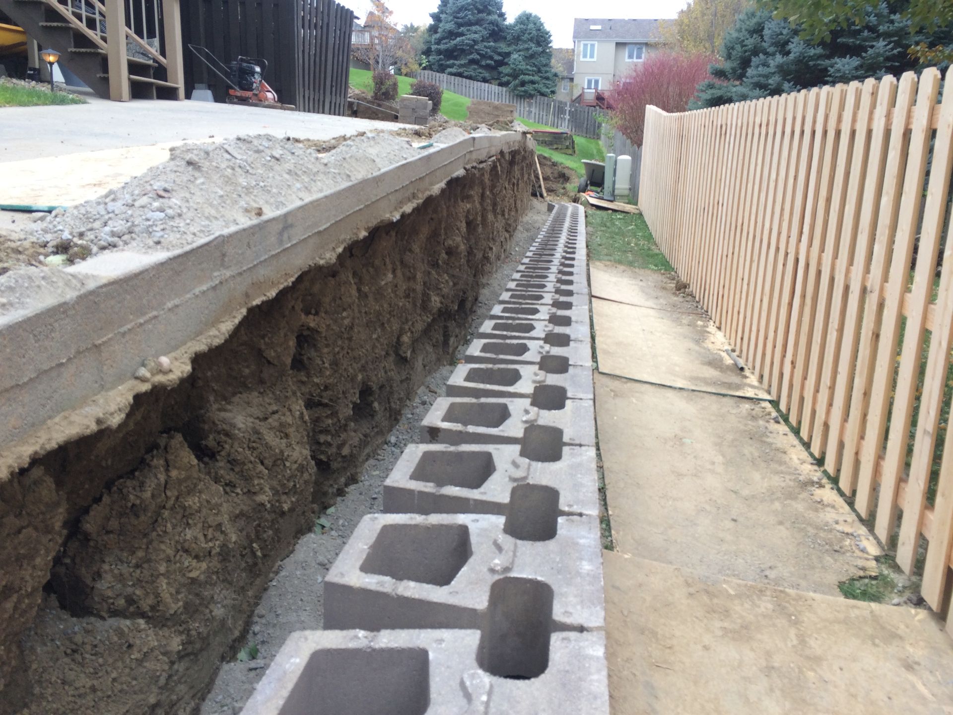 a concrete wall is being built next to a wooden fence