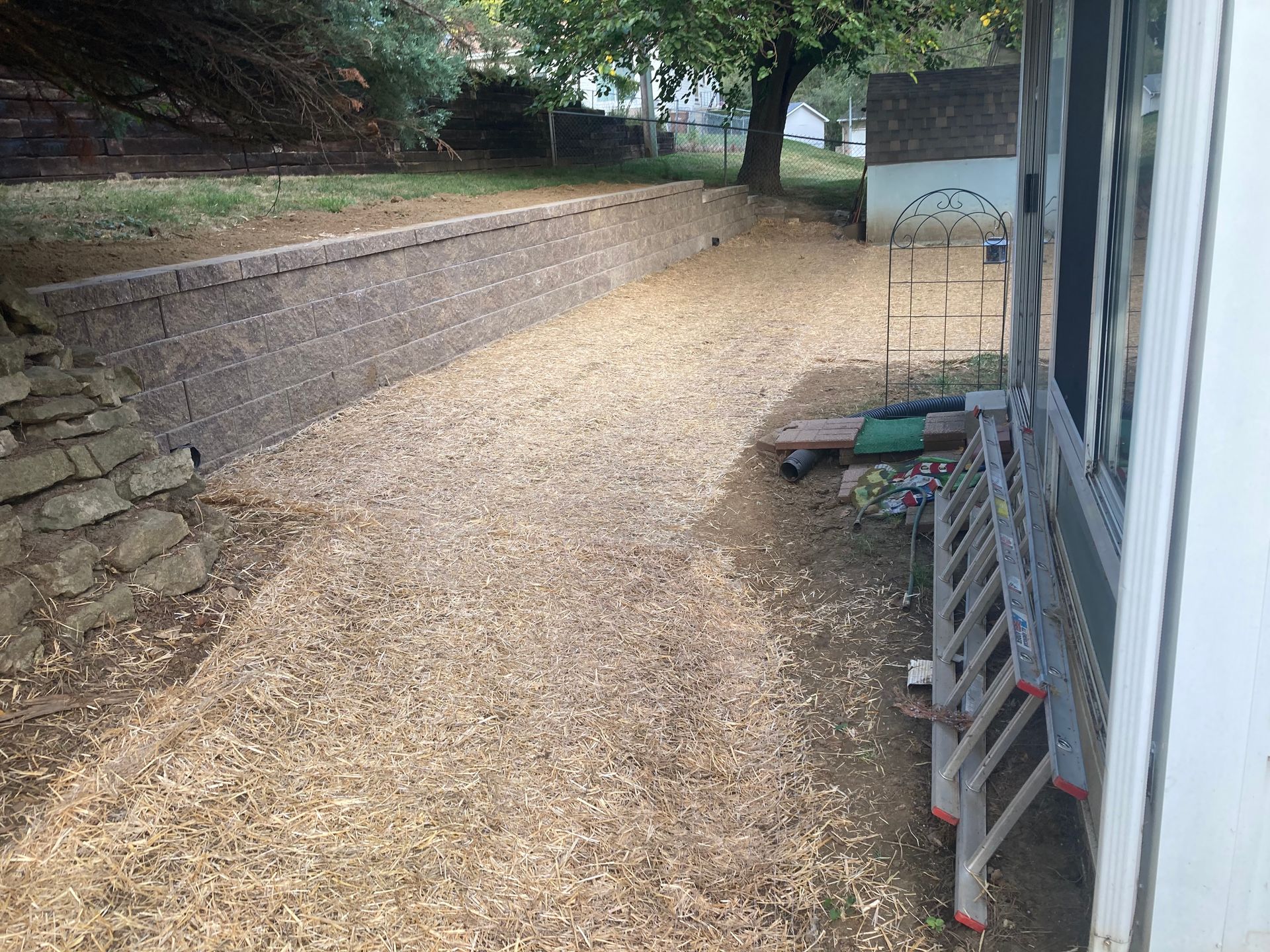 a ladder is sitting in the dirt in front of a house