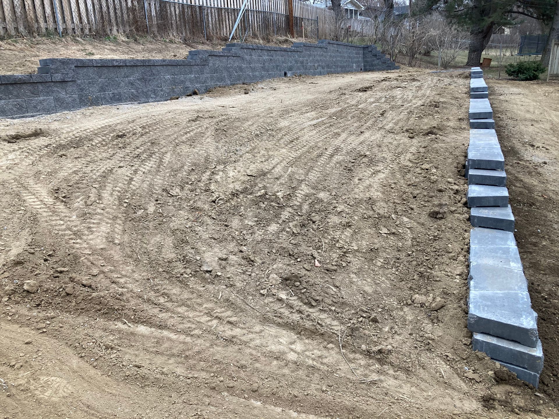 a concrete wall is being built in the middle of a dirt field